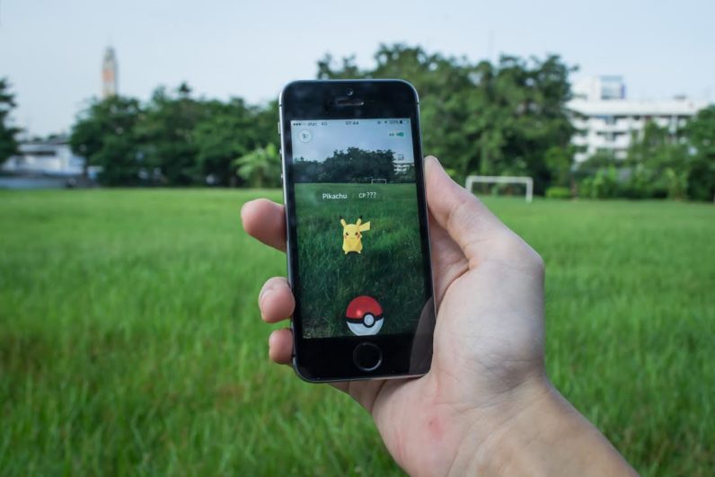 Hand holding a phone with Pokemon Go open